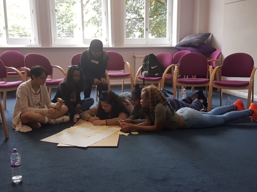 A photo of 6 young people working on a project together