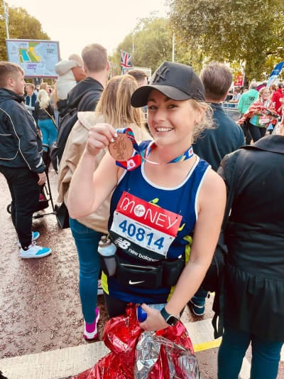Photo of a runner holding her London Marathon medal